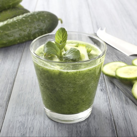 Cucumber and green smoothie on table