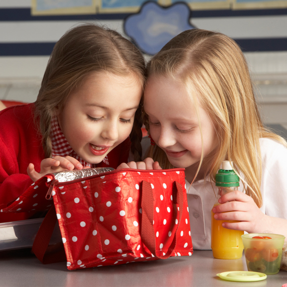 Two girls looking into lunch bag