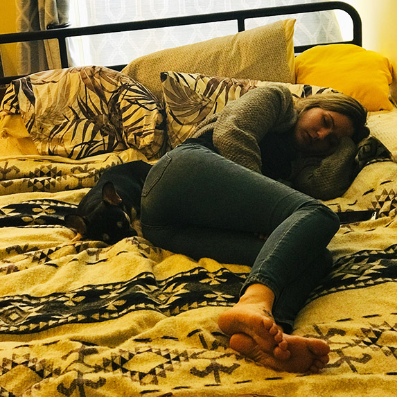 Canadian woman and dog sleeping in a bed