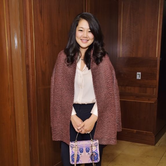 Crystal Kung Minkoff holding a purse.