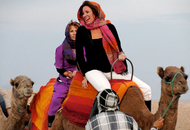 LuAnn riding a camel through the desert in Morocco
