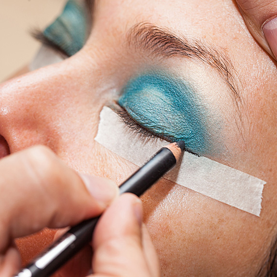 Applying eyeliner with tape under eyes