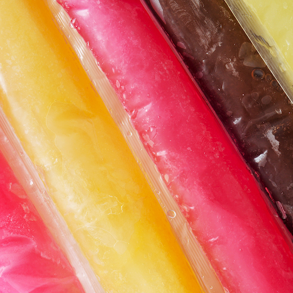 A closeup of some freezies of different colours and flavours