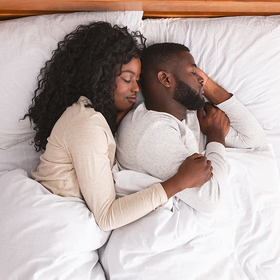 Couple sleeping in white bed