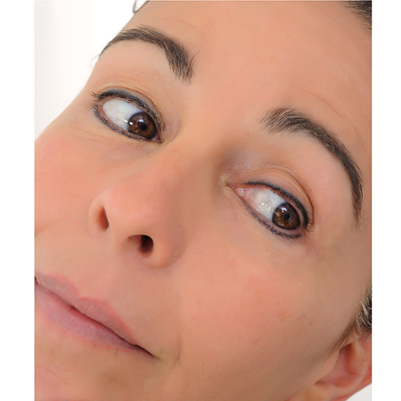 woman with permanent eyeliner looking in mirror