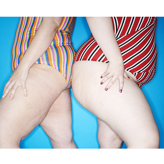 two curvy women leaning on each other