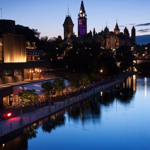 Shot of the lovely Rideau Canal at dusk with lights speckled in the background