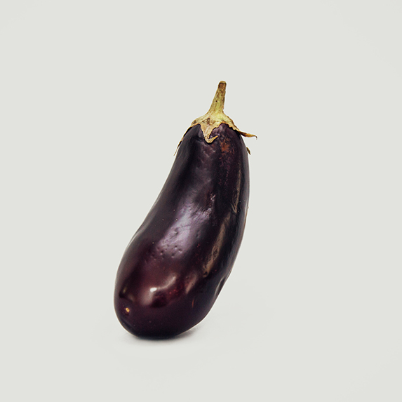 a bright purple eggplant against a white background