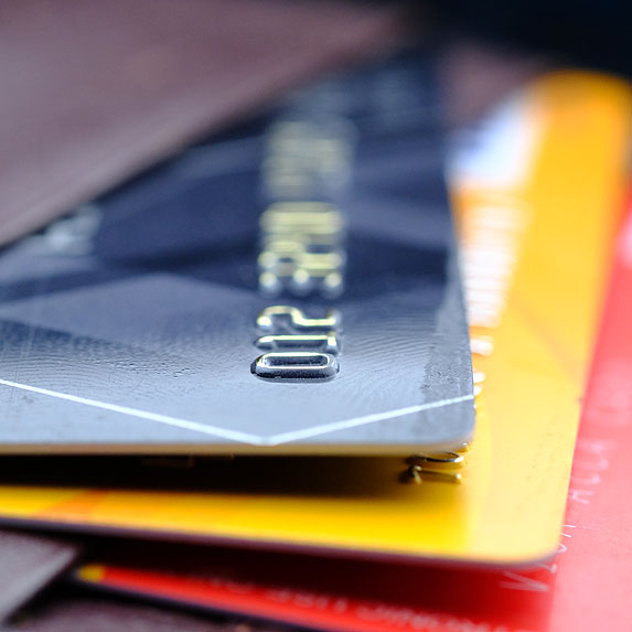 Blue, yellow, and red bank cards stacked on top of each other.