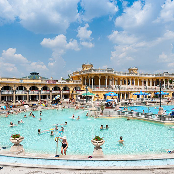 A group of bathers relaxing in the crystal-blue waters in the outdoor pool at the thermal baths