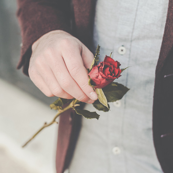 A person holding a single rose