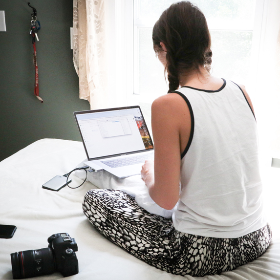 woman sitting on bed using computer