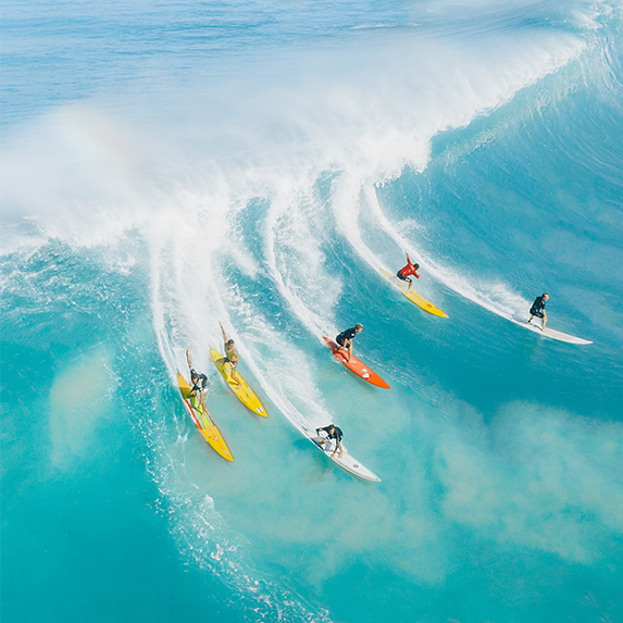 Several surfers riding a wave