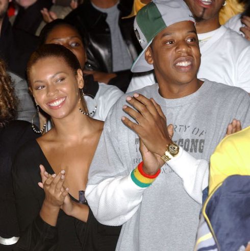 Jay-Z and Beyoncé sitting and clapping at an event