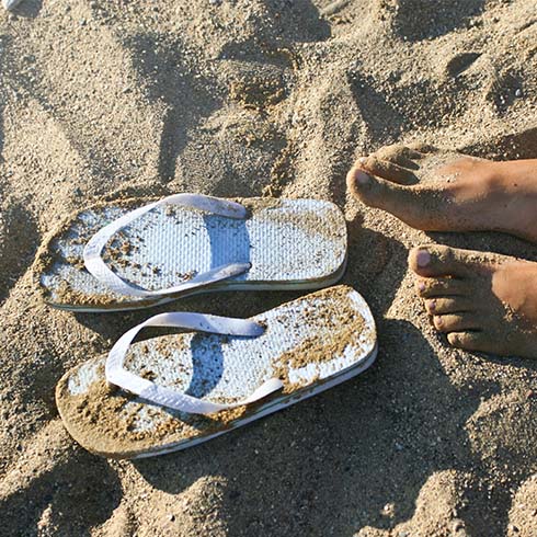 Flip-flops and feet on beach