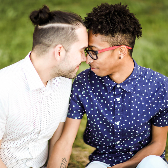 A young gay couple sitting together in the park