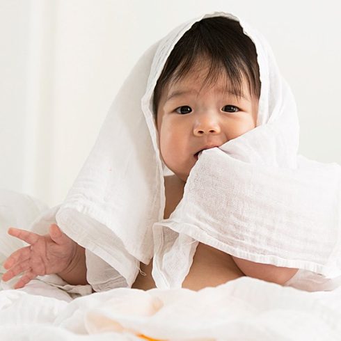 Cute Asian baby wrapped in a white cloth