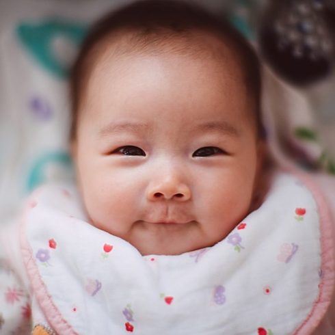 Smiling Asian baby girl smiling at the camera