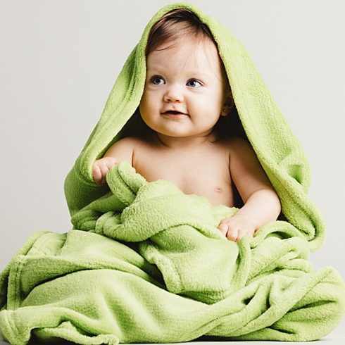 White baby girl wrapped in a lime green towel
