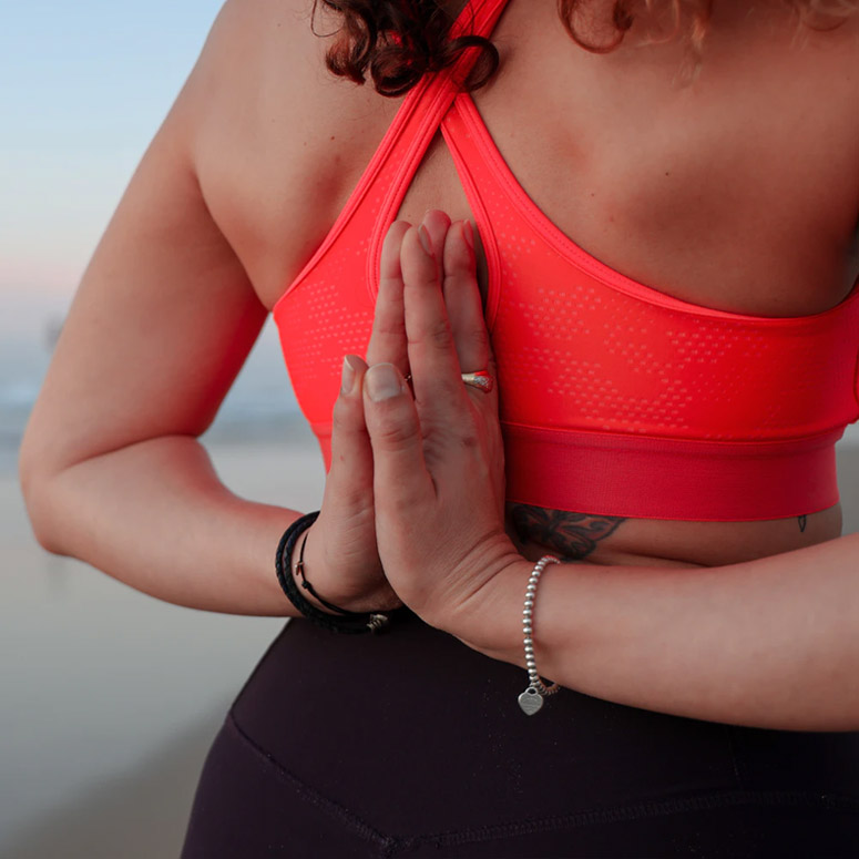 Body neutral woman holds hands together in yoga pose behind her back