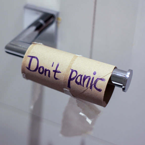 An empty toilet paper roll that has Don't Panic written on it