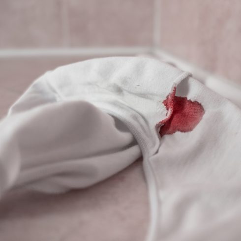 Blood stained white panties crumpled up on bathroom floor.