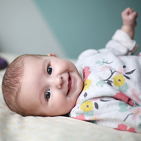 Baby girl smiling on a bed
