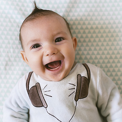 Laughing baby appliqued headphones on onesie