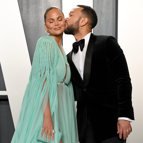 John Legend kisses wife Chrissy Teigen at an Oscar party