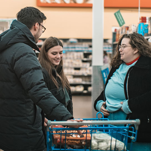 Three people shopping in the grocery