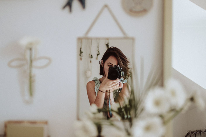 Woman takes a photo of herself through a mirror