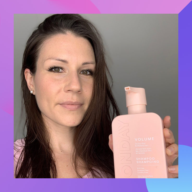 Dragana holding a bottle of Monday Haircare shampoo