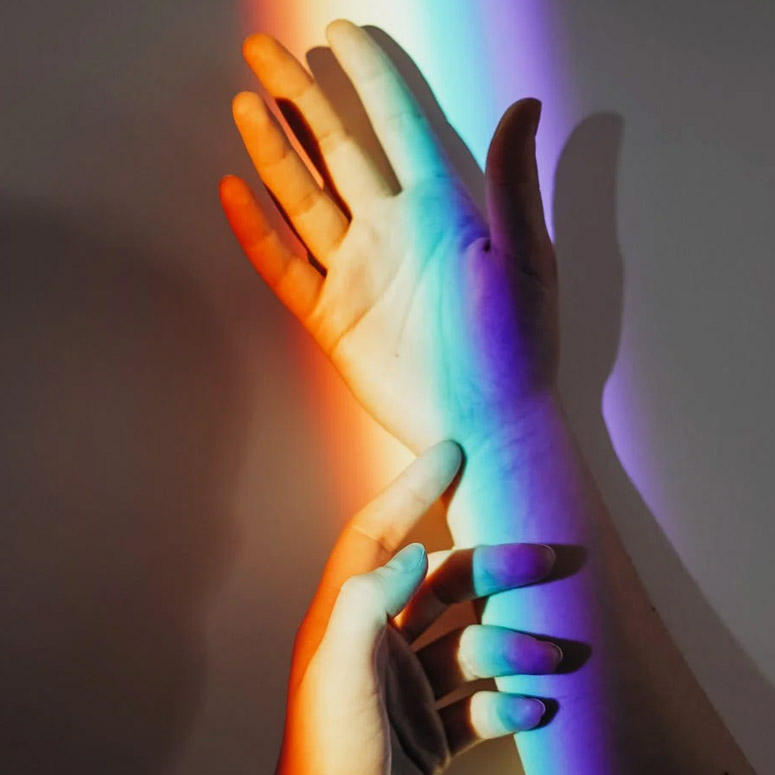Hands in rainbow light