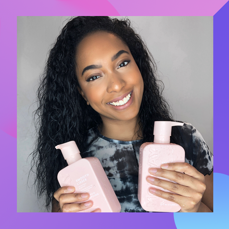 Tracey holding two bottles of Monday Haircare products