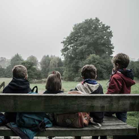 Four kids sitting on a bench