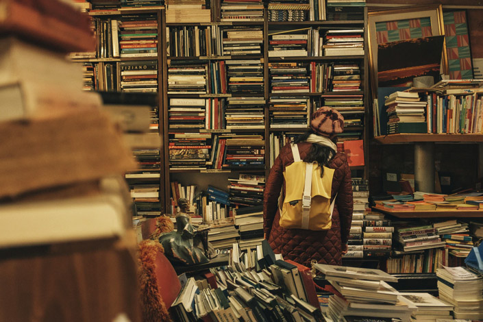 Person with backpack in a bookstore