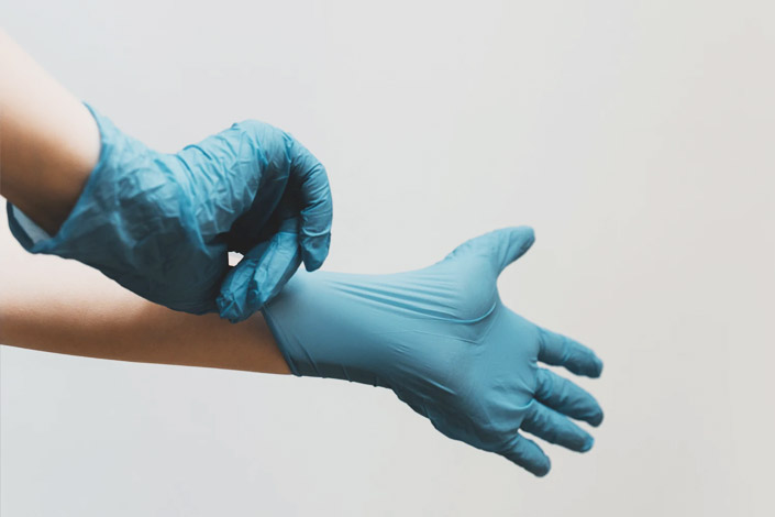 Person pulling latex glove on their hand