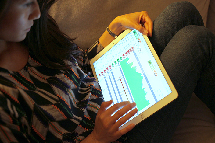 Woman looking at stocks on her tablet