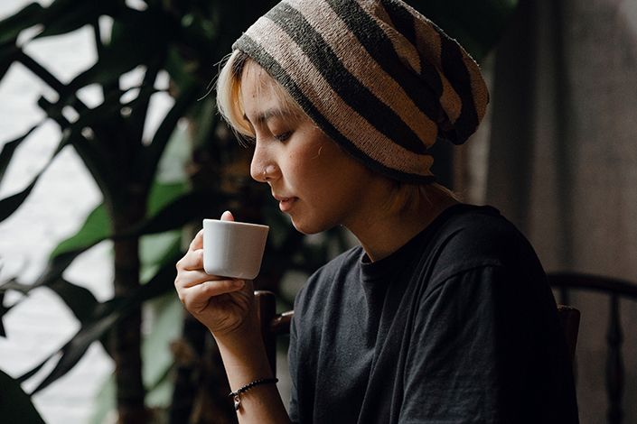Woman in beanie holding an espresso cup