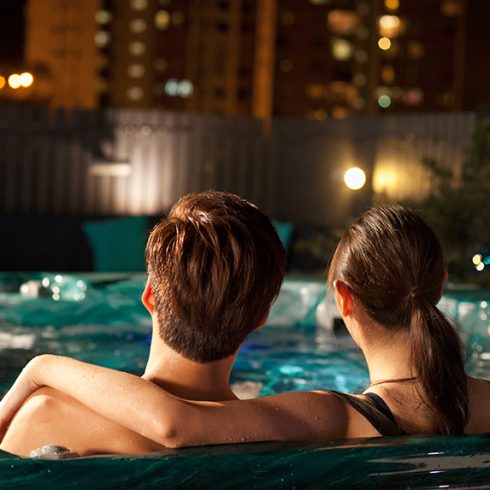 Couple sitting in a hot tub at night