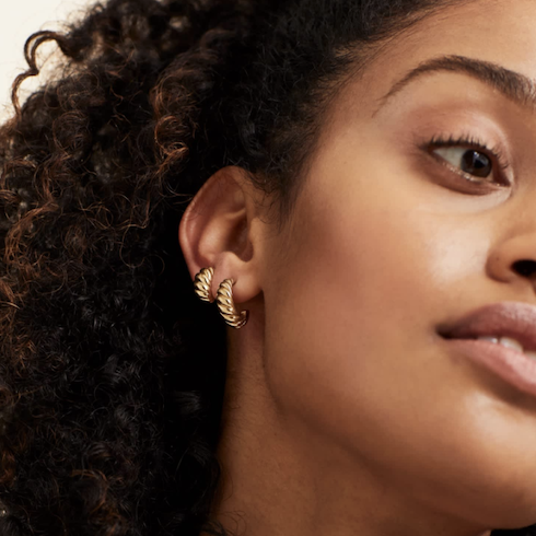 close up of womans face with thick gold hoop earrings