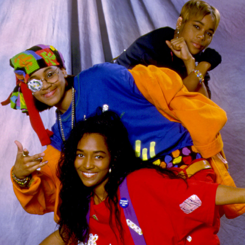 TLC posing as a group with colourful, baggy clothes