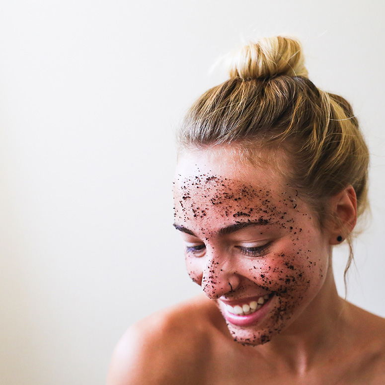 a young white woman looking off camera with a face scrub on