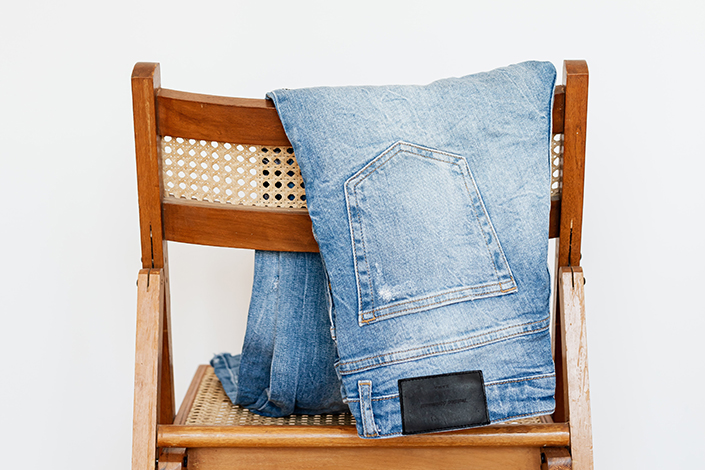 a pair of faded jeans folded over a chair