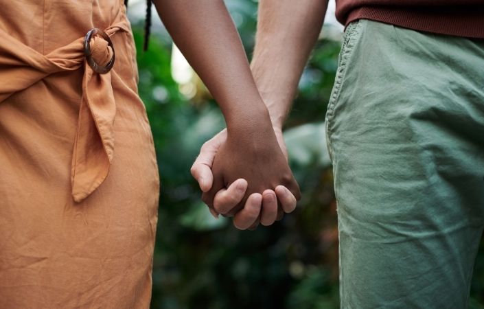 A close up of two people holding hands 