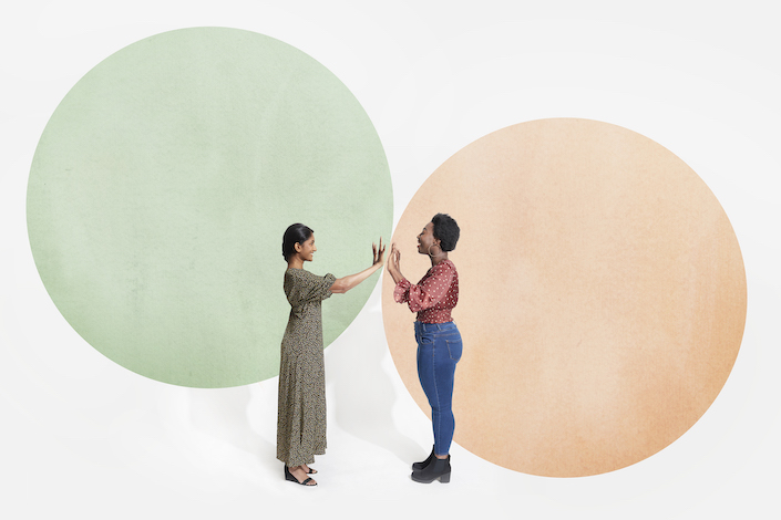 Two women stand opposite one another in their respective illustrated boundary circles