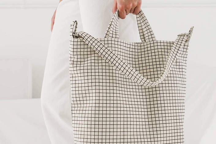 a checkered tote bag being held by a woman