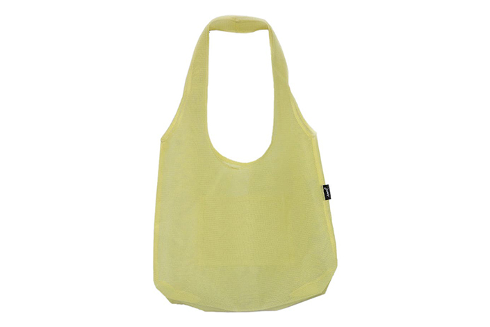 a pale yellow-green tote bag against a white background