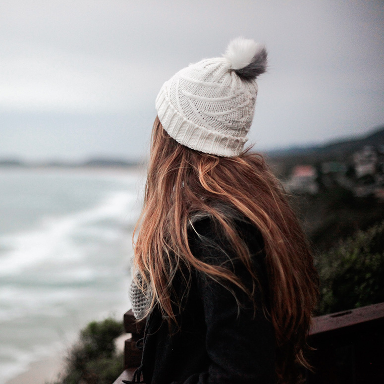 Women looking out to a stormy sea or lake with a toque on