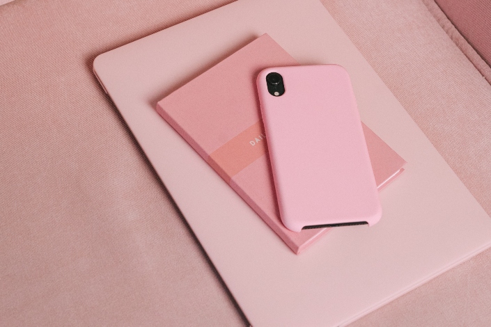 A pink laptop, notebook and smartphone